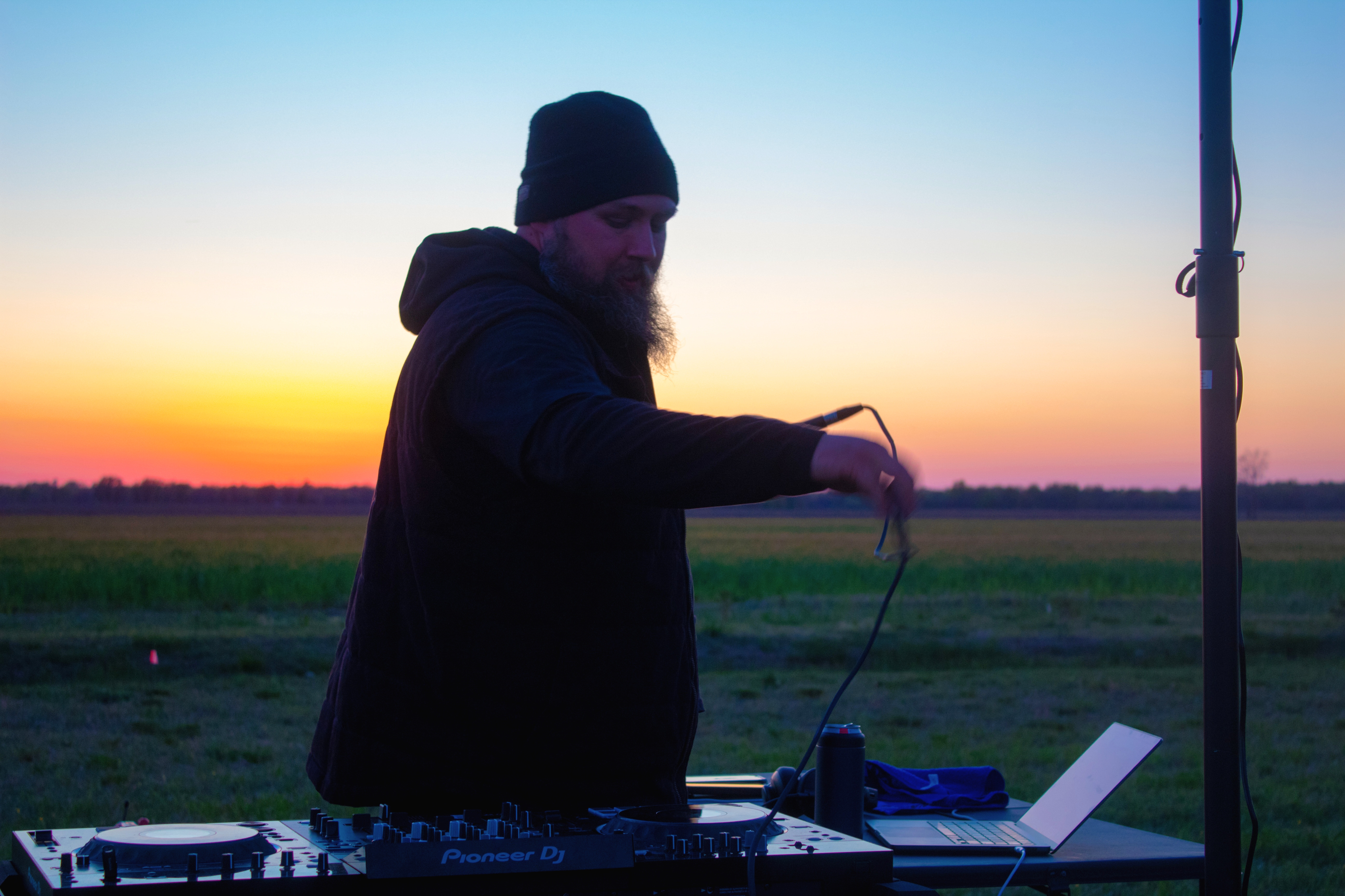 Travis Barnes performing an outdoor DJ set at sunset